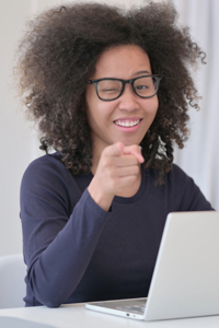 African Woman with Laptop Pointing at Camera
